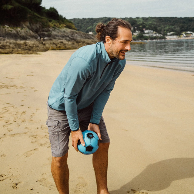 Man on the beach wearing a Jellymud Men's Quarter Zip Sweatshirt. Made from bamboo and organic cotton.