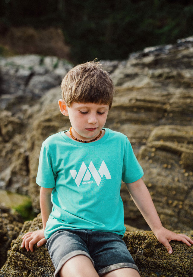 Front view of Jellymud Kids' Columbus Bamboo T-Shirt. Boy wearing the tee on the beach.