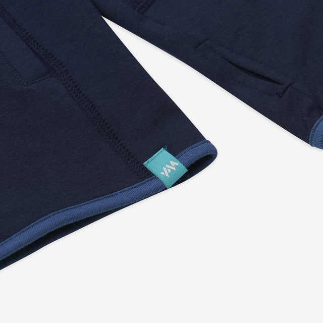 Jellymud womens navy bamboo pullover. Close up of hem and thumbhole detail.